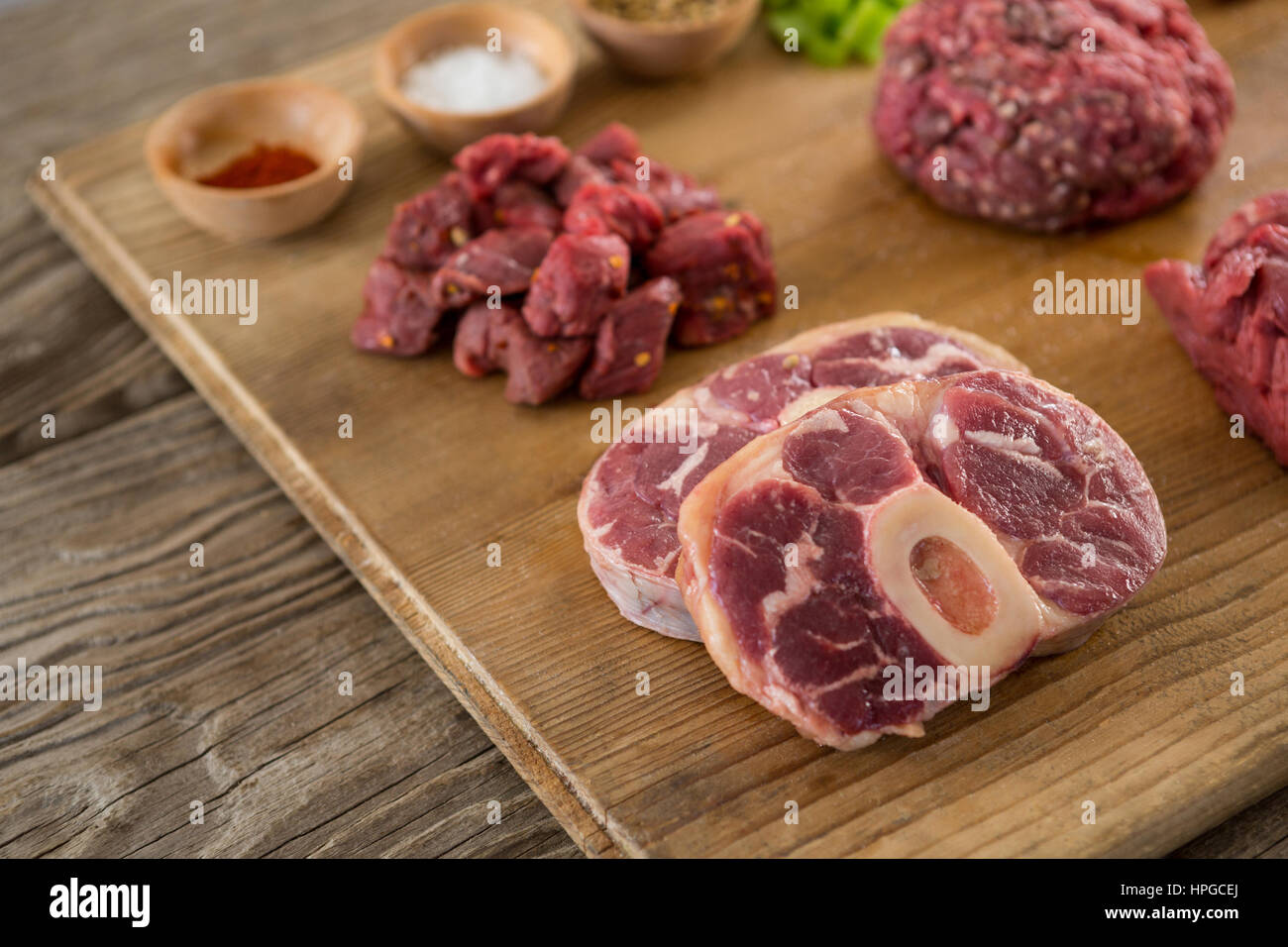 Sorten von Fleisch und Gewürzen auf Holztablett aus Holz Hintergrund Stockfoto