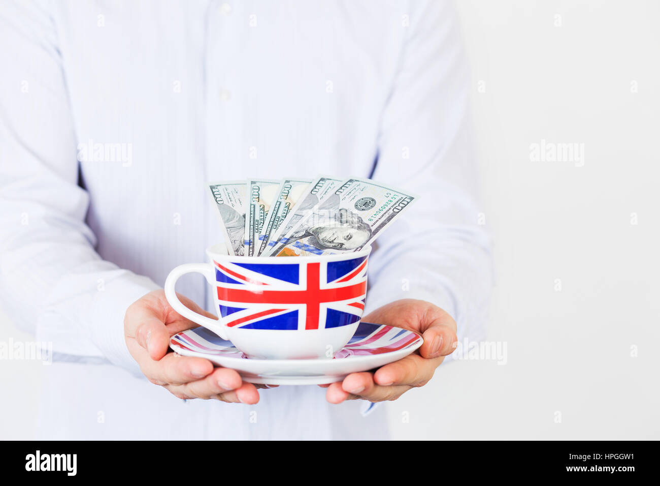 Geschäftsmann mit Bargeld-Dollar-Scheine in einer Tasse gemalt wie Union Jack-Flagge Stockfoto