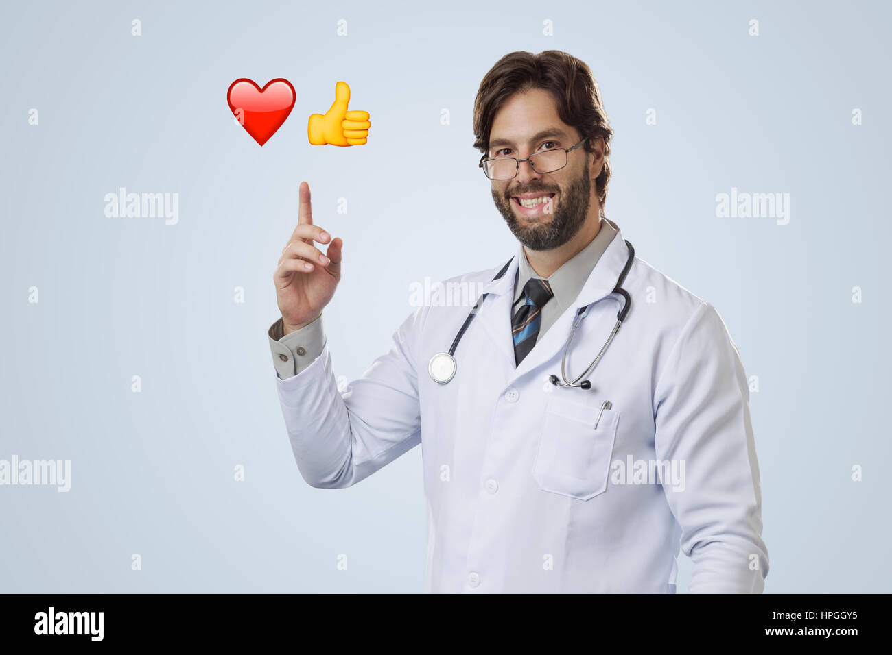 Männlichen Arzt auf einem grauen Hintergrund deuten einige Emojis. Stockfoto