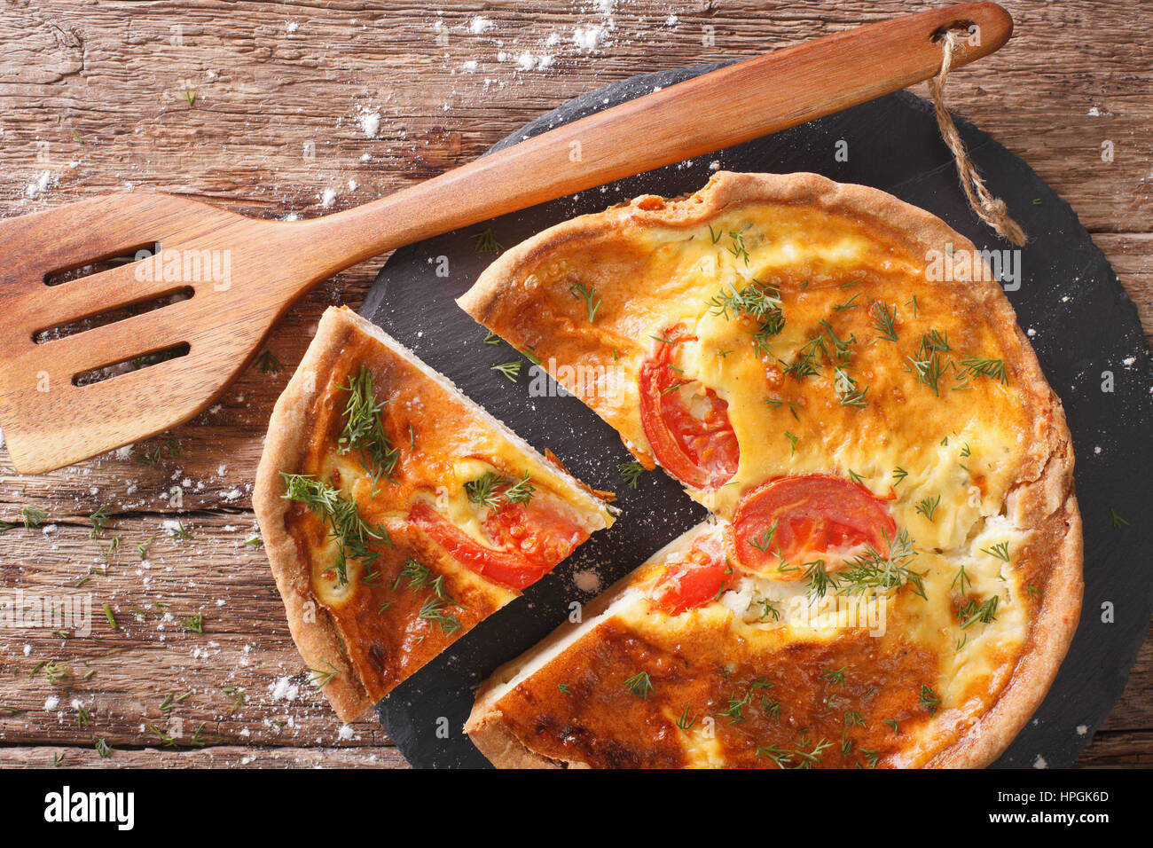 Frisch geschnittene Kuchen mit Feta, Tomaten und Kräutern Closeup auf dem Tisch. horizontale Ansicht von oben Stockfoto