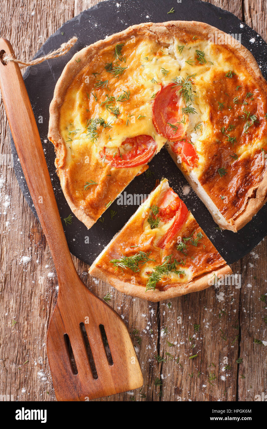 Frisch geschnittene Kuchen mit Feta, Tomaten und Kräutern Closeup auf dem Tisch. vertikale Ansicht von oben Stockfoto