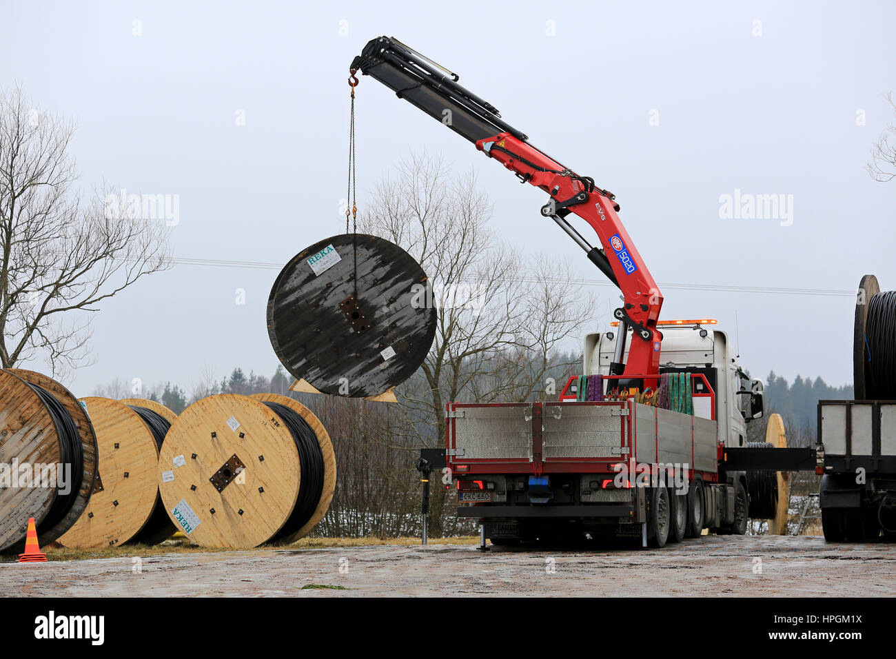 SALO, Finnland - 17. Februar 2017: LKW montierten Kran entlädt macht Kabeltrommeln auf jeden Baustelle. Im Bereich werden Freileitungen repl Stockfoto