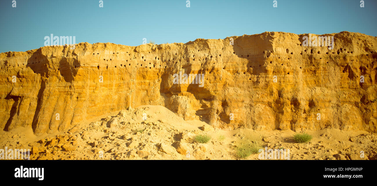 Klippe der gelb orange braun Sand Boden Ton unter den sonnigen Tag mit tiefblauen Himmel Stockfoto