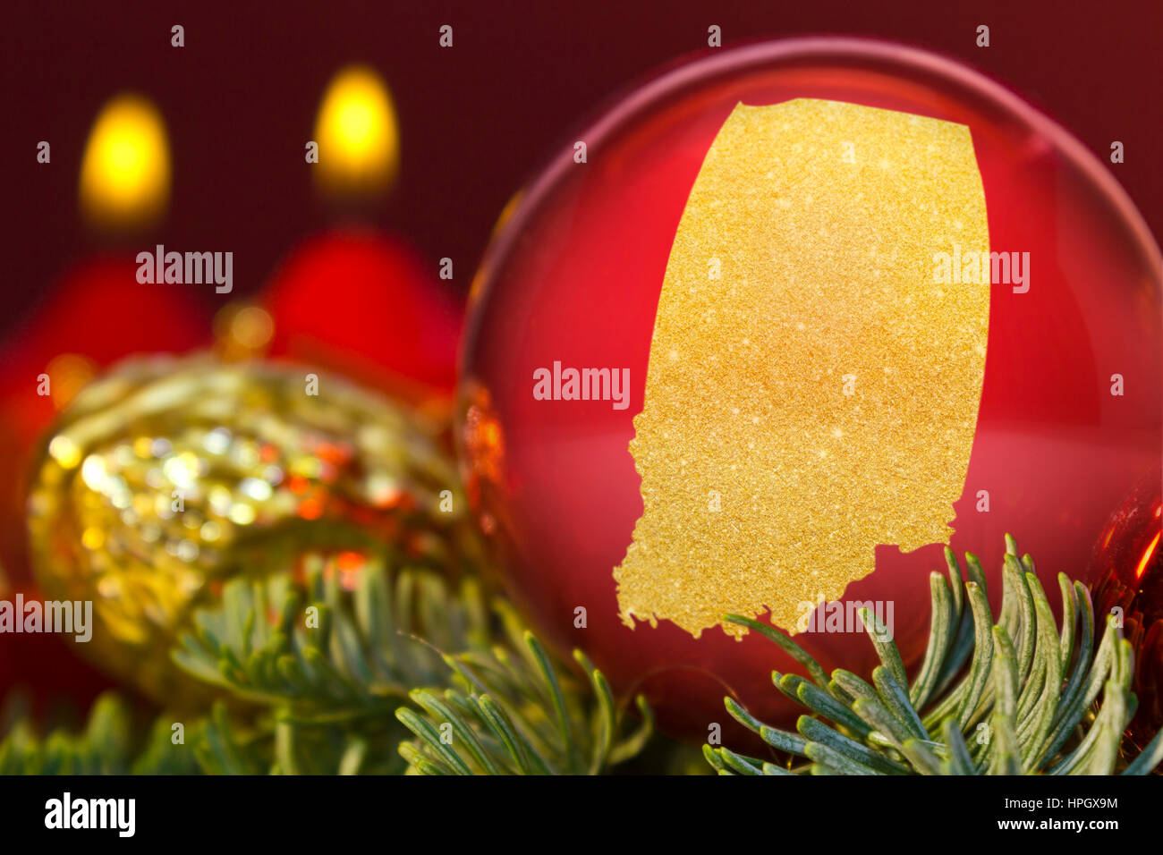 Eine glänzende rote Christbaumkugel mit der goldenen Form von Indiana. (Serie) Stockfoto