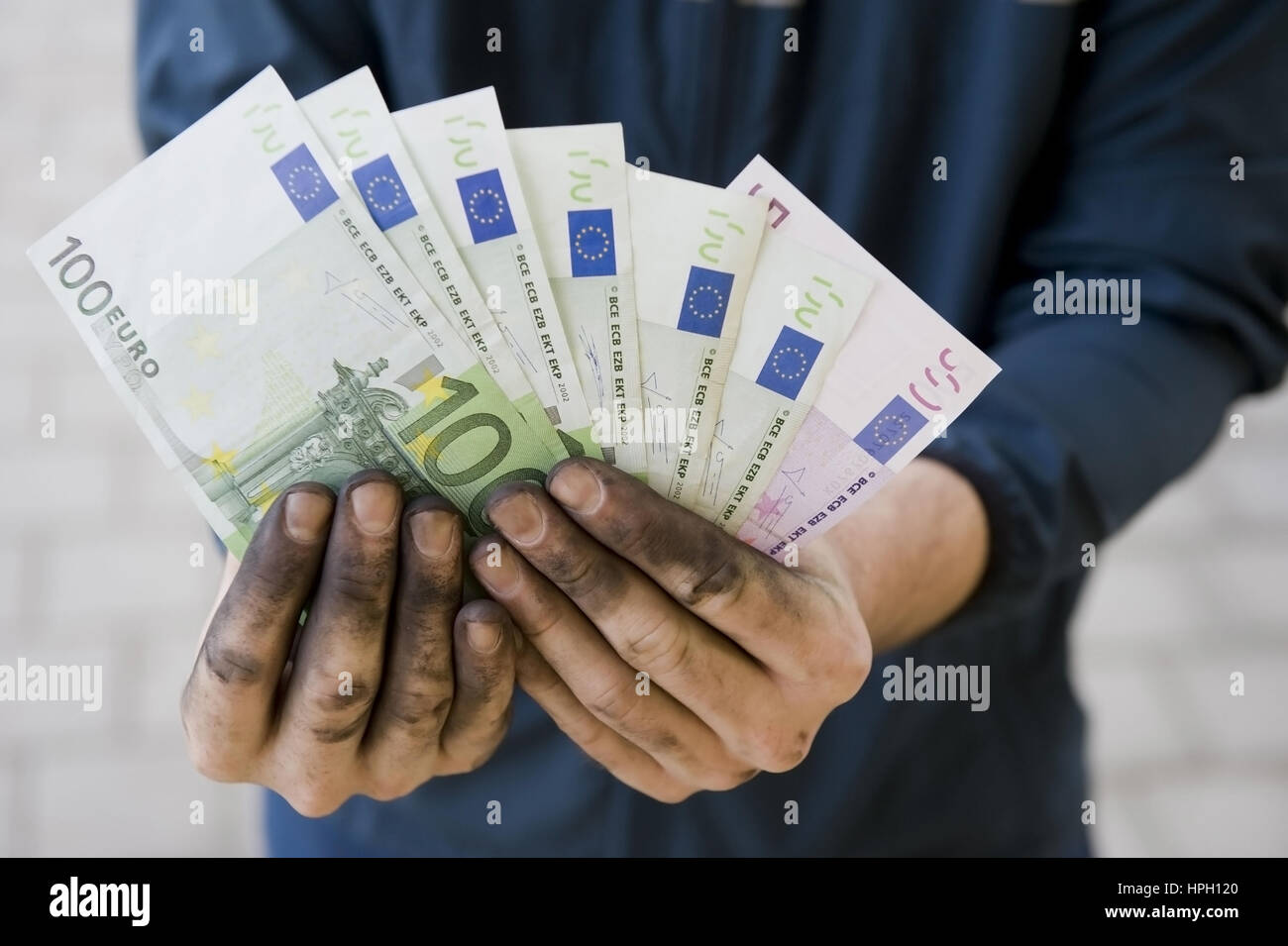 Model Release, Symbolbild Schwarzgeld, Arbeiter Mit Aktion Haenden Haelt Geldscheine - symbolisch für Schwarzgeld Stockfoto