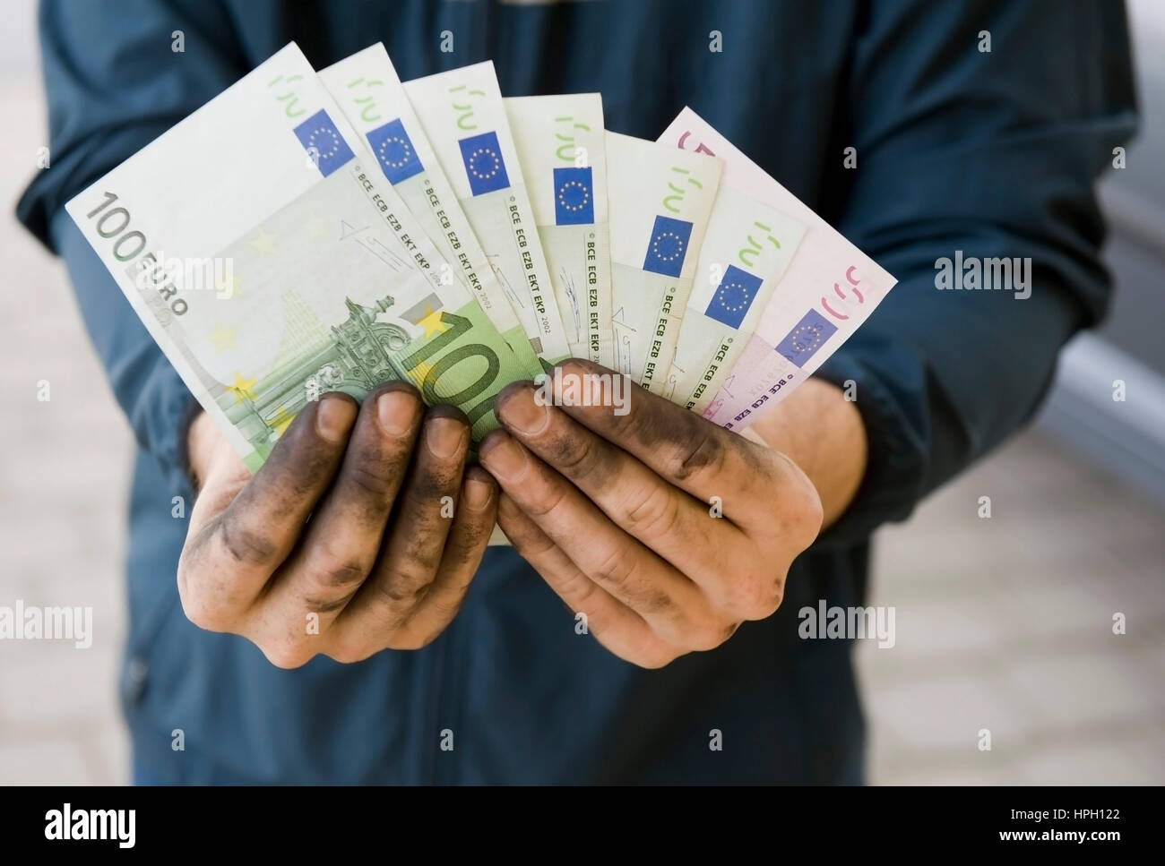 Model Release, Symbolbild Schwarzgeld, Arbeiter Mit Aktion Haenden Haelt Geldscheine - symbolisch für Schwarzgeld Stockfoto