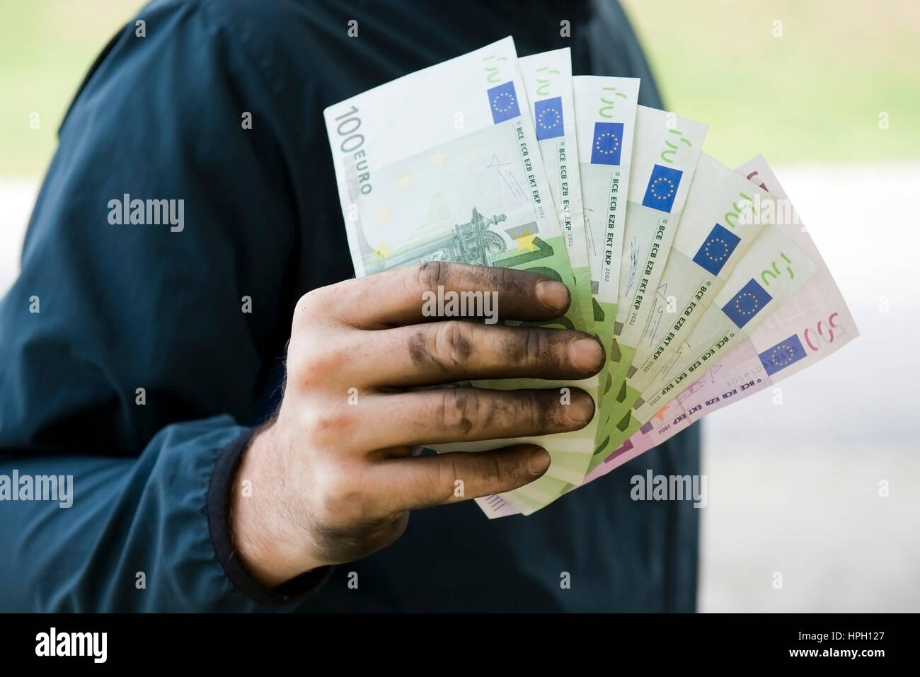 Model Release, Symbolbild Schwarzgeld, Arbeiter Mit Aktion Haenden Haelt Geldscheine - symbolisch für Schwarzgeld Stockfoto