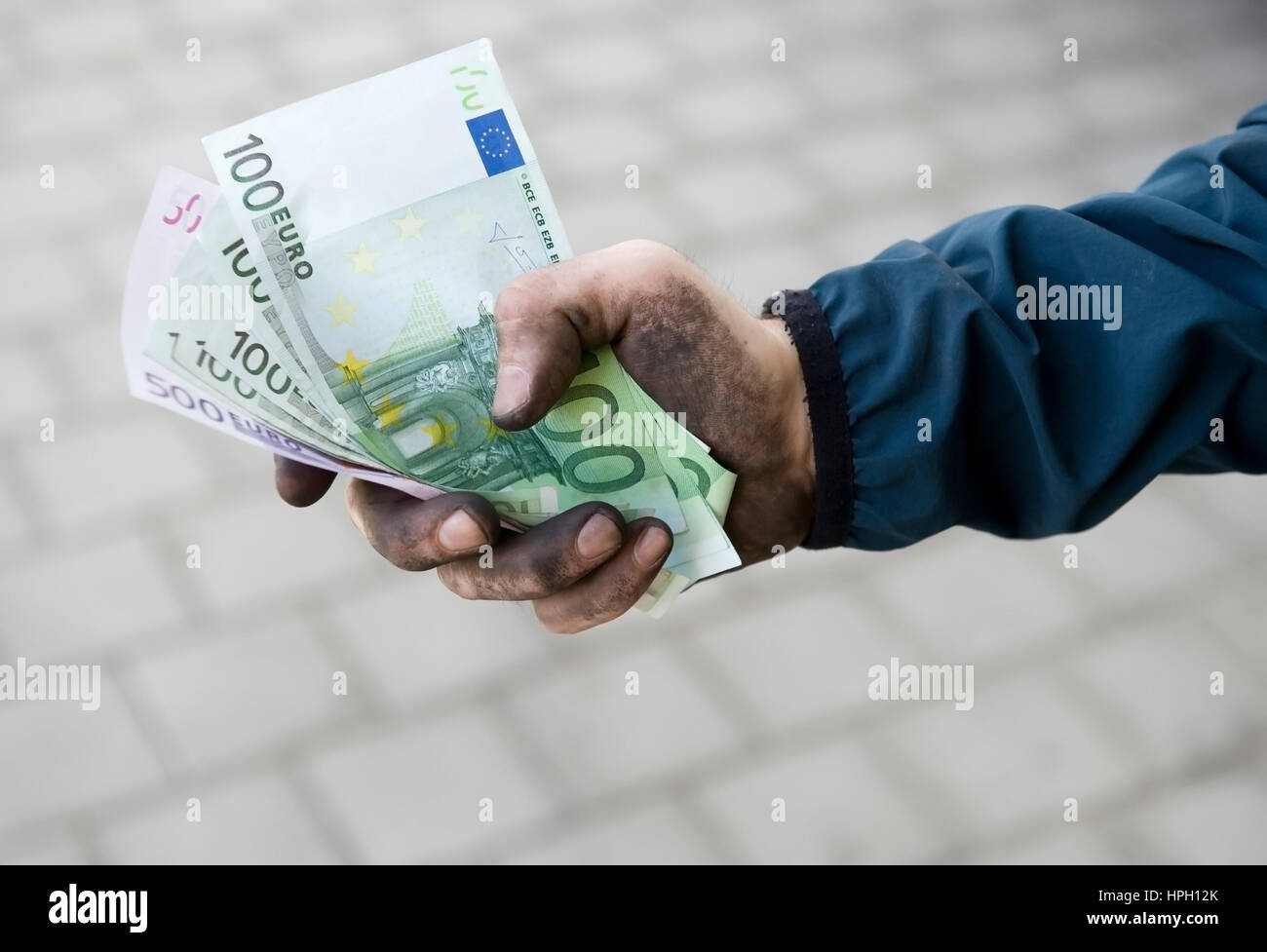 Model Release, Symbolbild Schwarzgeld, Arbeiter Mit Aktion Haenden Haelt Geldscheine - symbolisch für Schwarzgeld Stockfoto