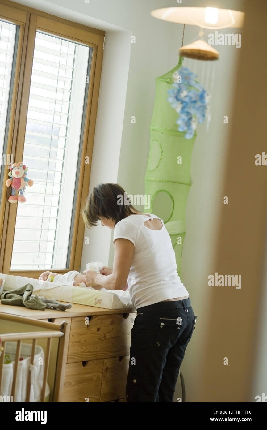 Model Release, Mutter Beim Windelnwechseln Im Kinderzimmer - Mutter mit Baby auf dem Wickeltisch Stockfoto