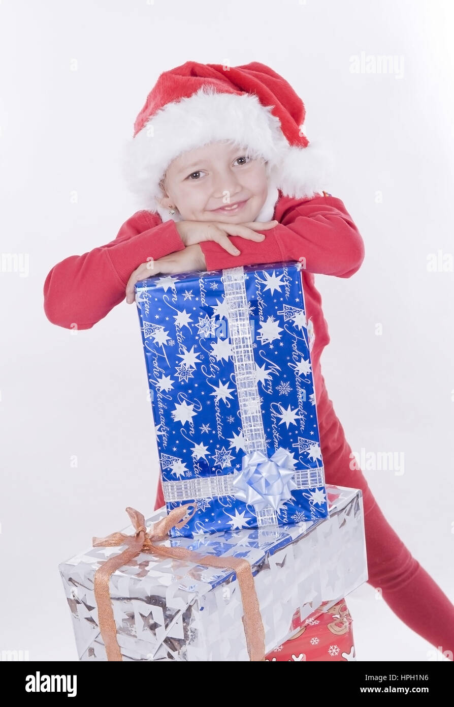 Modell veröffentlicht, stellt näher Mit Weihnachtsmuetze Und Weihnachtsgeschenken - Weihnachten-Mädchen mit Stockfoto