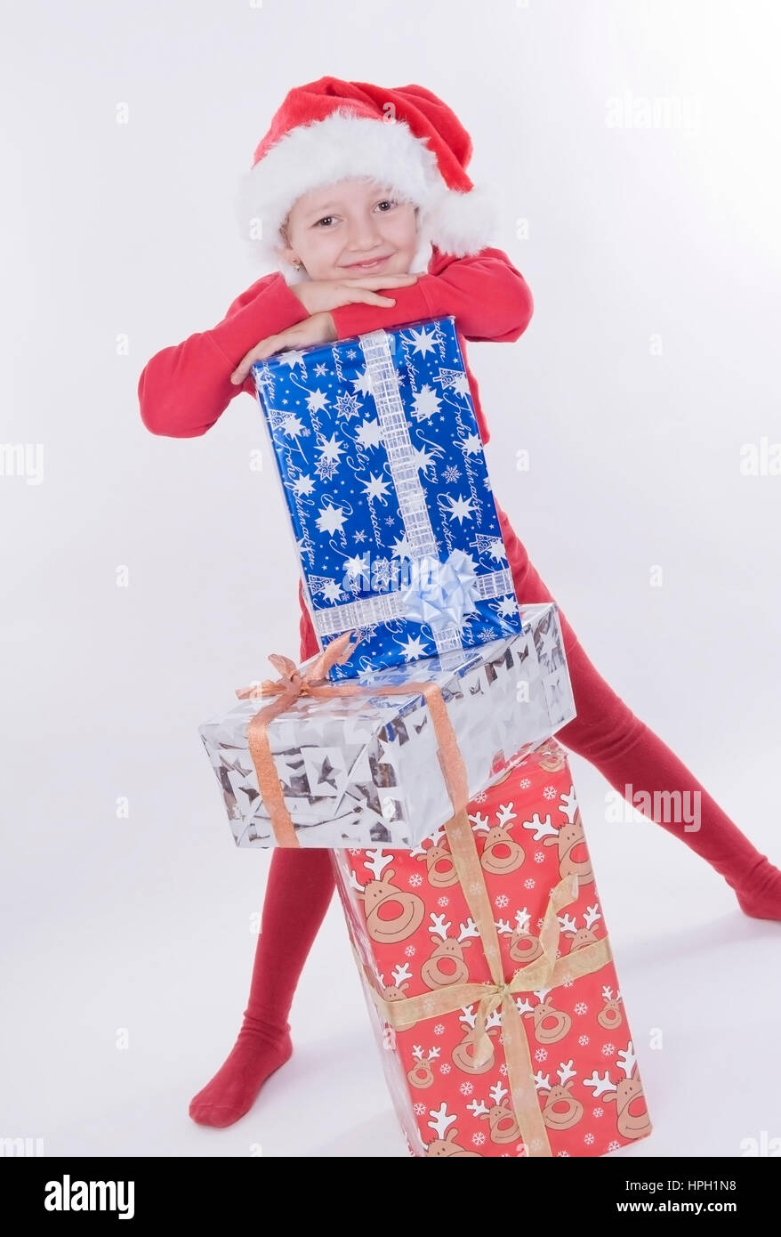 Modell veröffentlicht, stellt näher Mit Weihnachtsmuetze Und Weihnachtsgeschenken - Weihnachten-Mädchen mit Stockfoto