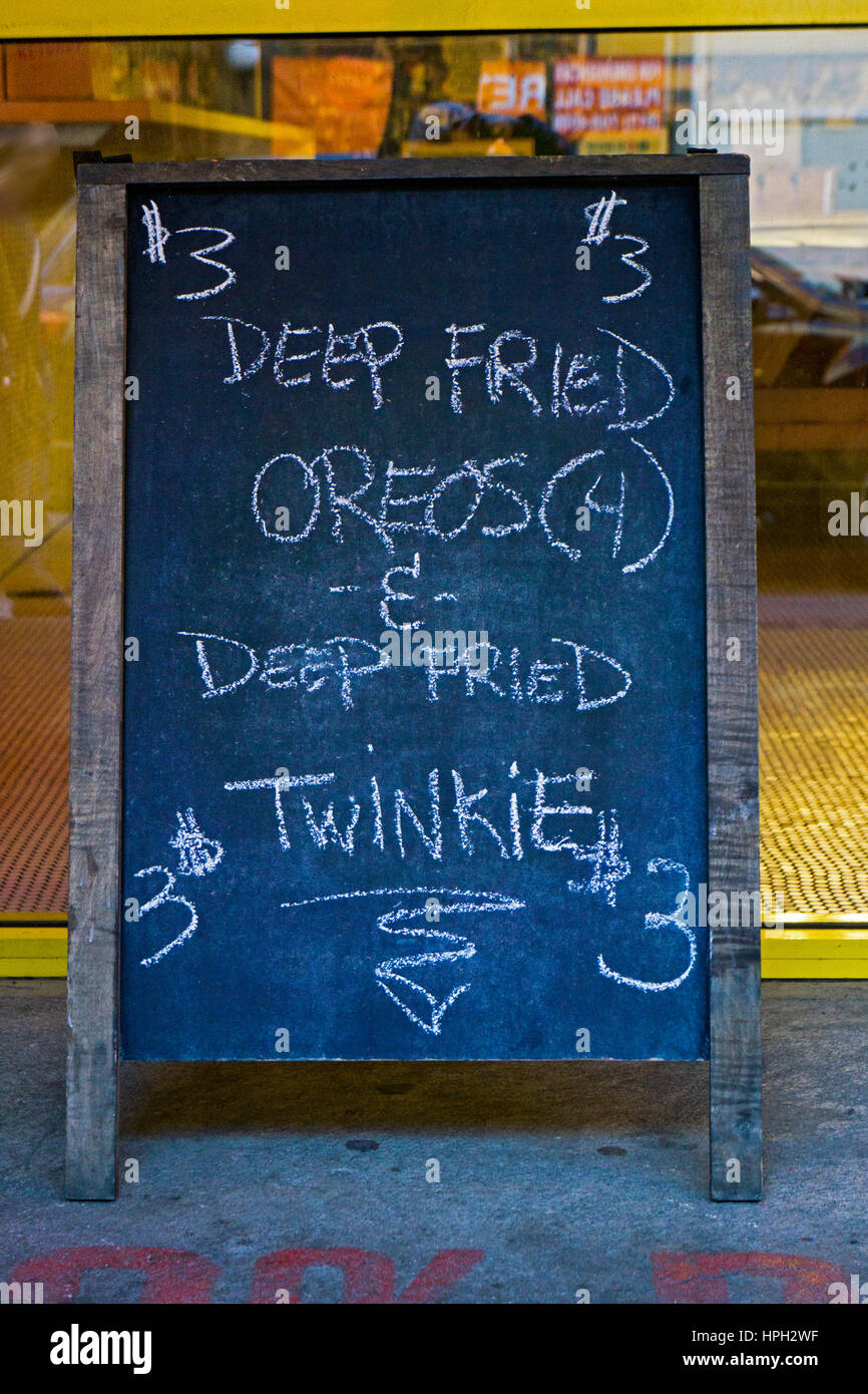Ein Zeichen außerhalb Papaya King in Greenwich Village in New York Werbung frittiert Oreo Cookies und Twinkies frittiert. Stockfoto
