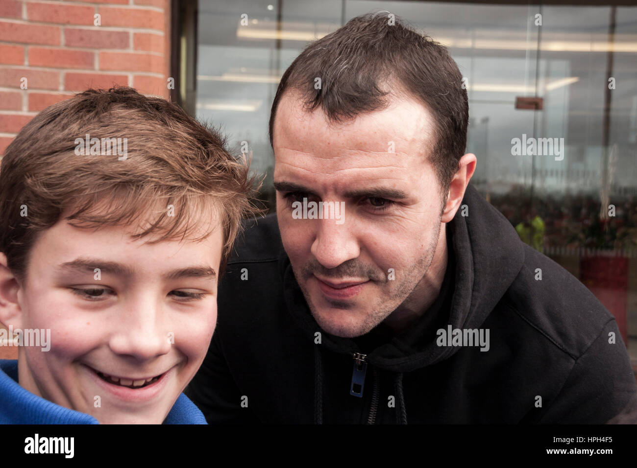 Sunderland Kapitän, John O'Shea, posiert für ein Selbstporträt mit einem jungen außerhalb der Stadium of Light, Sunderland, England Stockfoto