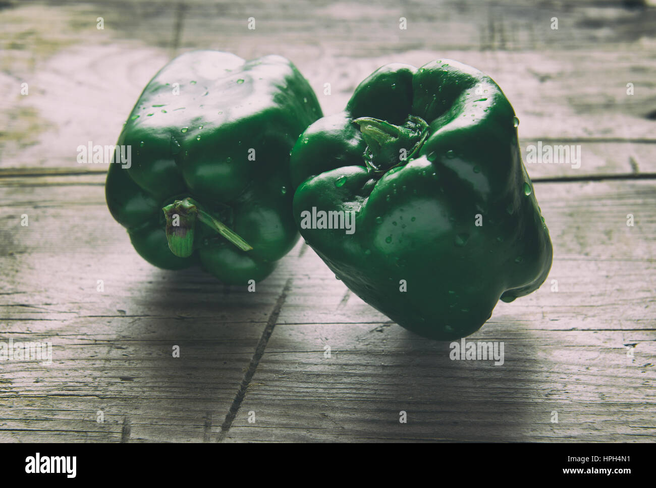 grüner Paprika auf Holztisch hautnah. Retro-Stil Foto Stockfoto