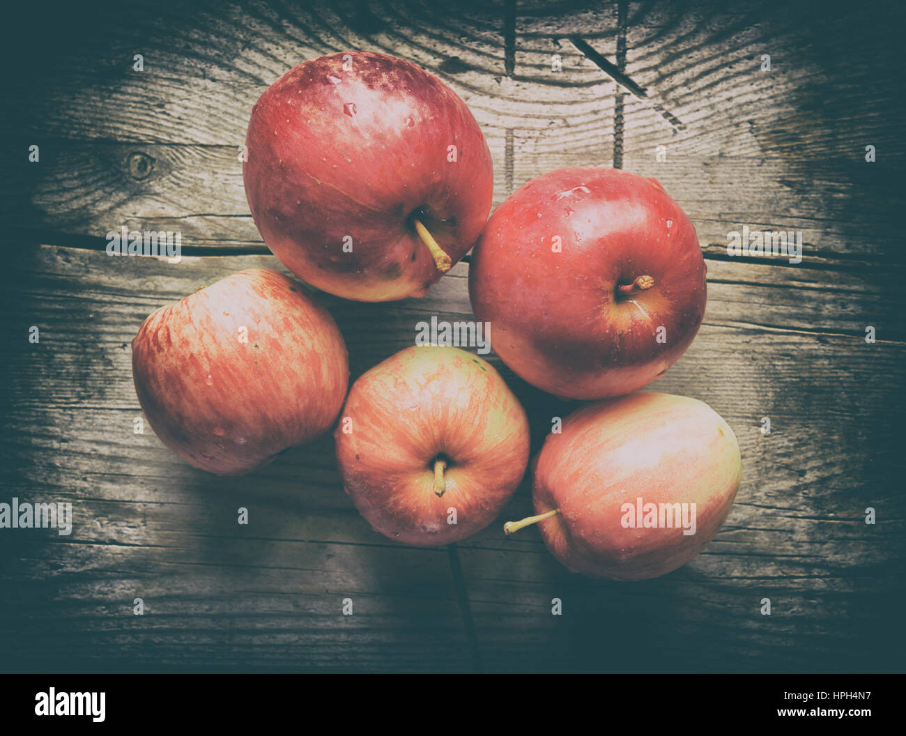 rote Äpfel auf hölzernen Hintergrund. Retro-Stil Foto Stockfoto