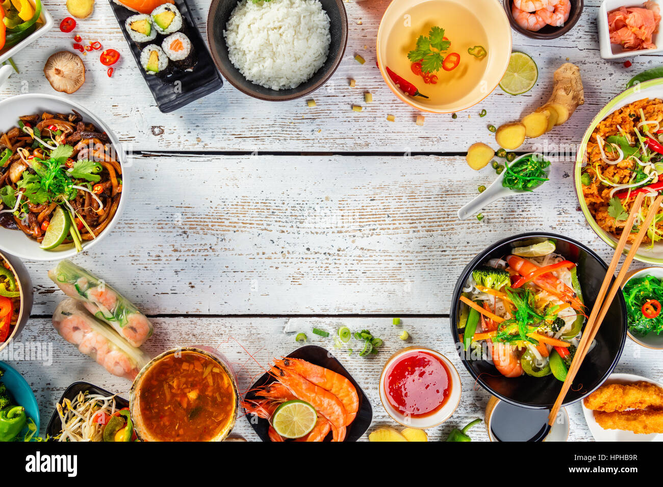 Asiatische Speisen auf weißer Holztisch, Draufsicht, Platz für Text. Chinesische und vietnamesische Küche gesetzt. Stockfoto