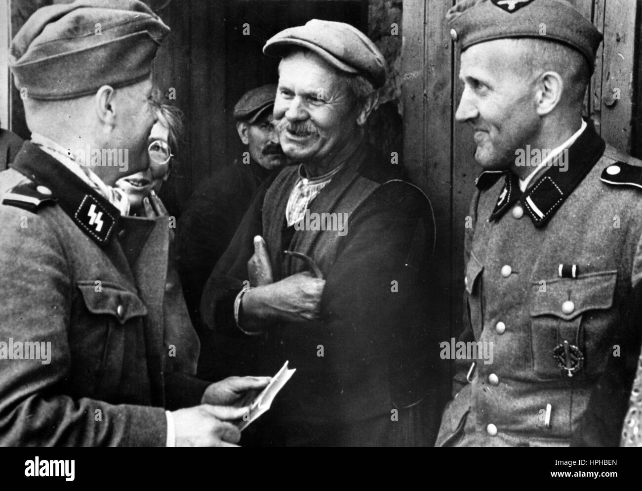 Das Bild der Nazi-Propaganda zeigt belgische Flüchtlinge und SS-Streitkräfte in besetzten französischen Air-sur-la-Lys. Veröffentlicht im Juni 1940. Ein Nazi-Reporter hat auf die Rückseite des Bildes von 11.06.1940 geschrieben, 'vom westlichen Kriegstheater. Die Belgier, die nach Frankreich geflohen sind und Zuflucht suchen, unterhalten sich mit den SS-Streitkräften in Aire." Fotoarchiv für Zeitgeschichte - NICHT FÜR DEN KABELDIENST - | weltweite Verwendung Stockfoto