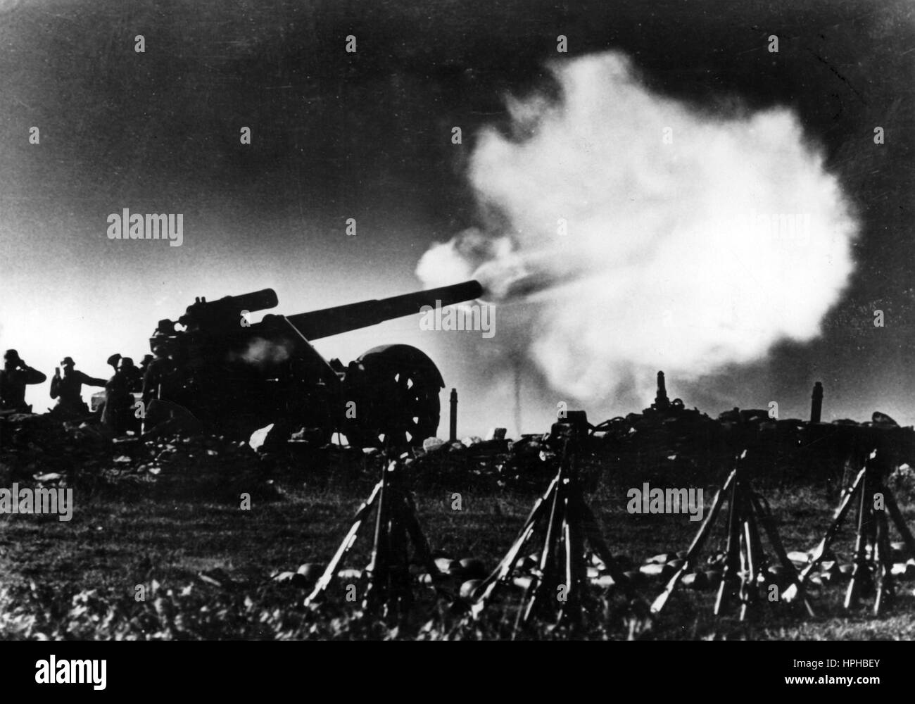 Das Bild der Nazi-Propaganda zeigt einen deutschen Wehrmachtssoldaten, der eine Waffe auf die Westfront schießt. Veröffentlicht im Februar 1941. Ein Nazi-Reporter hat auf der Rückseite des Bildes auf 14.02.1941 geschrieben: "Wenn schwere Artillerie feuert... Der Schuss fliegt raus. Die Granate heult, während sie ihr feindliches Ziel jagt. Fotoarchiv für Zeitgeschichte - NICHT FÜR DEN KABELDIENST - | weltweite Verwendung Stockfoto