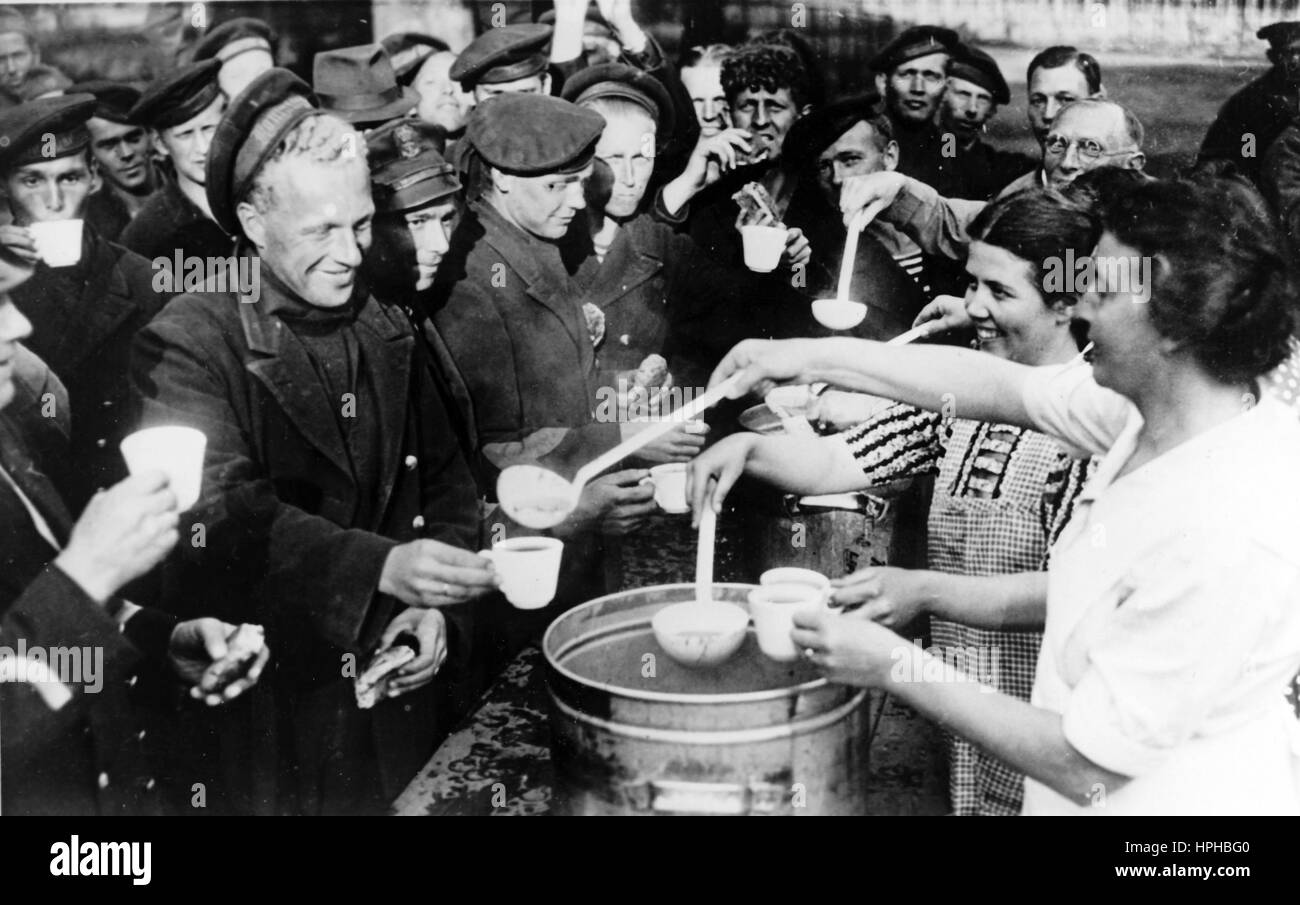 Das Bild der Nazi-Propaganda zeigt niederländische Kriegsgefangene, die während der deutschen Besatzungszeit in Dutsch Enschede mit Nahrung versorgt werden. Veröffentlicht im Juni 1940. Ein Nazi-Reporter hat auf der Rückseite des Bildes auf 15.06.1940 geschrieben: "Die holländischen Kriegsgefangenen sind aus Deutschland in ihre Heimat zurückgekehrt. Während ihrer Rückkehr nach Enschede werden die holländischen Matrosen gefüttert." Fotoarchiv für Zeitgeschichte - NICHT FÜR DEN KABELDIENST - | weltweite Verwendung Stockfoto