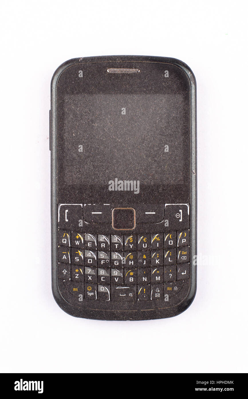 Vorderansicht Nahaufnahme von alten Schwarz Smartphone Handy mit QWERTZ- Tastatur mit Staub bedeckt und isoliert auf weißem Hintergrund  Stockfotografie - Alamy