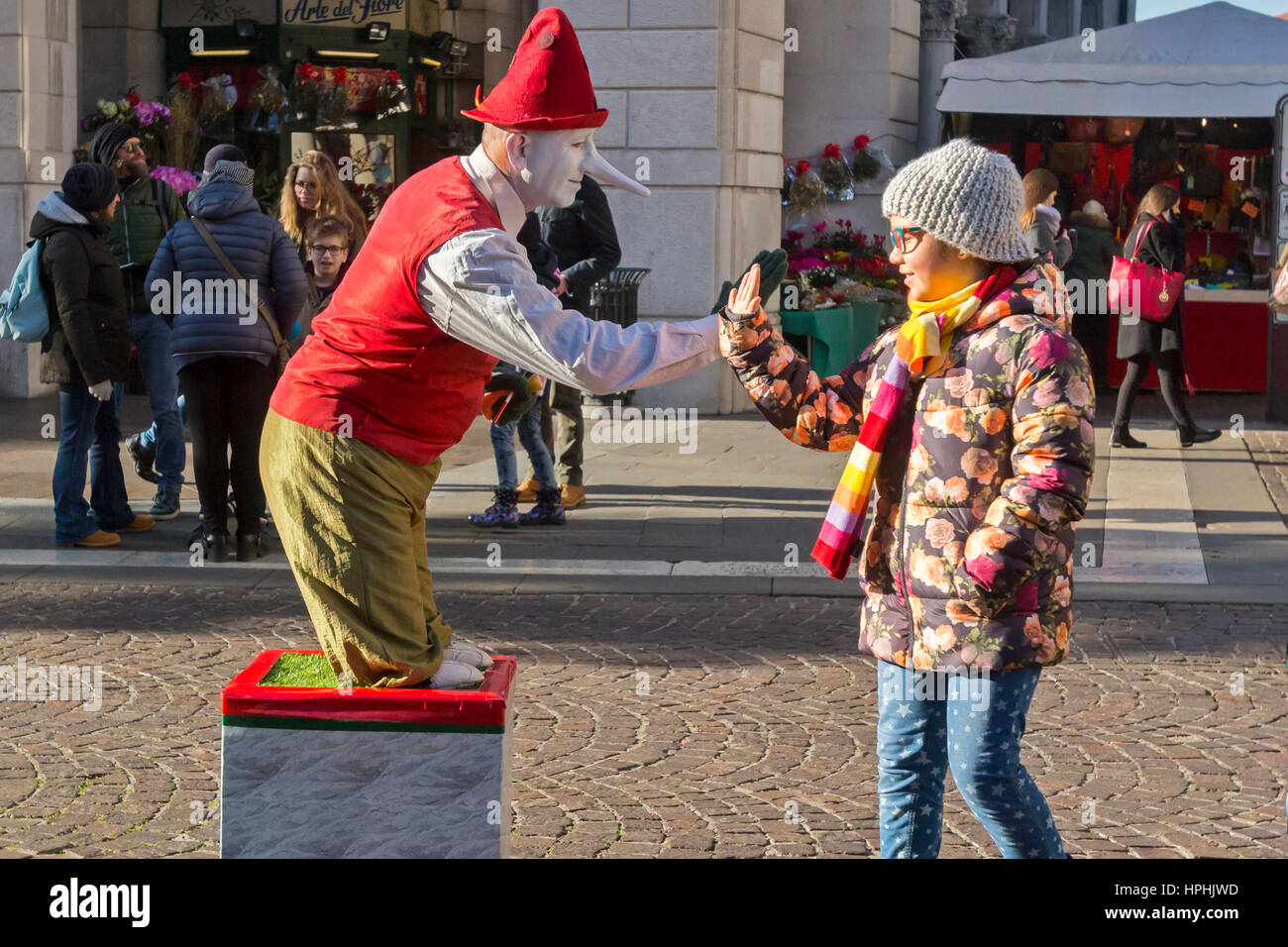 Eine Straße Clown unterhält eine junge Dame. Stockfoto