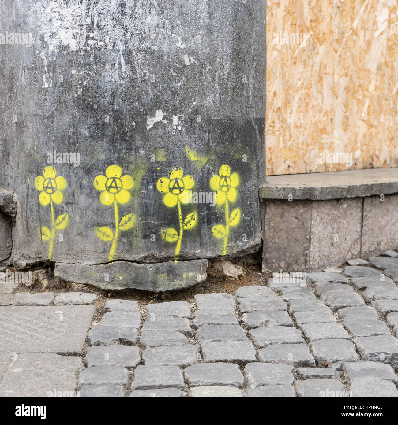Gelbe Blumen als Graffiti auf eine graue Wand Stockfoto