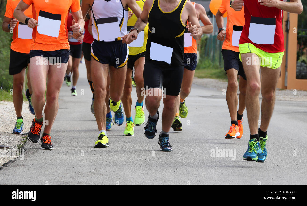 viele Athleten während des Rennens der Straße in der Stadt auf die asphaltierte Straße und weißen Startnummer Stockfoto