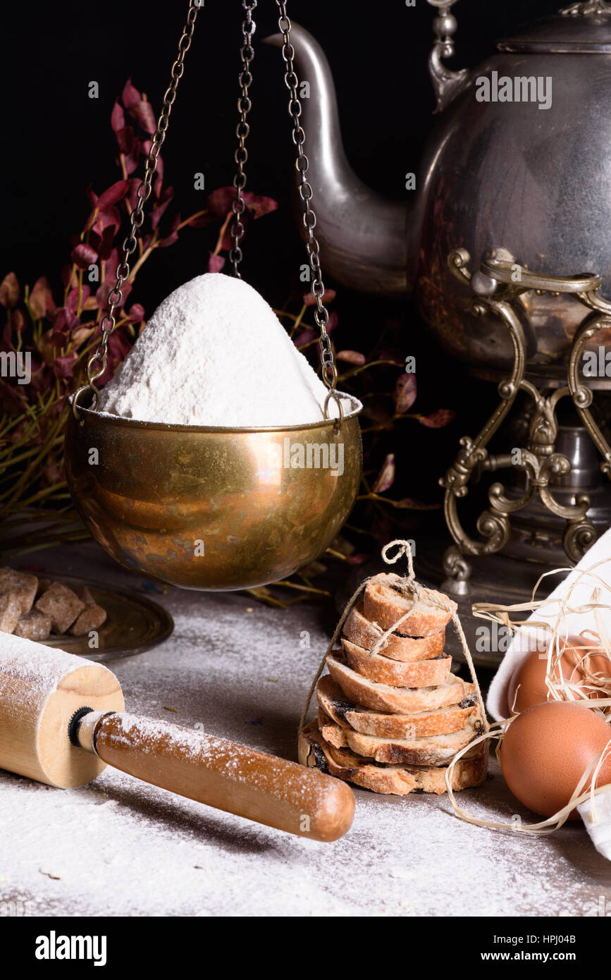 Backzutaten - Mehl, Eiern, Backpulver Brot. Mehlbasis Essen Stilleben mit antiken Teekanne gebacken. Stockfoto