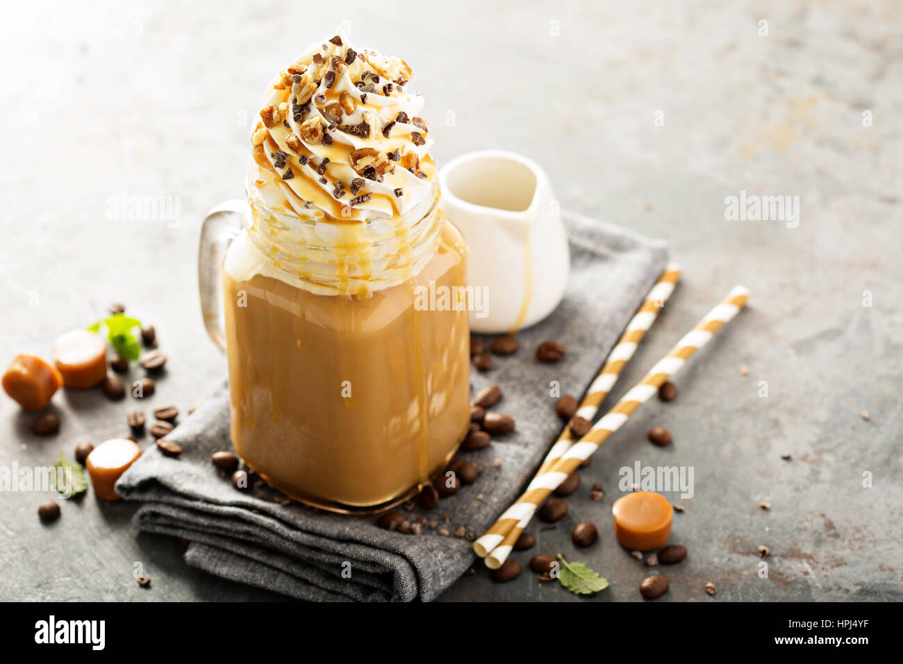 Caramel iced Latte mit Sahne und Sirup auf hellem Hintergrund Stockfoto