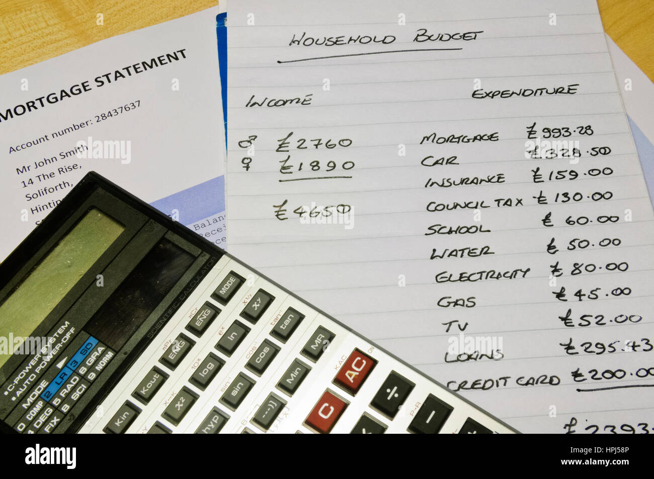 Haushaltskasse mit Taschenrechner und Hypothek Stockfoto