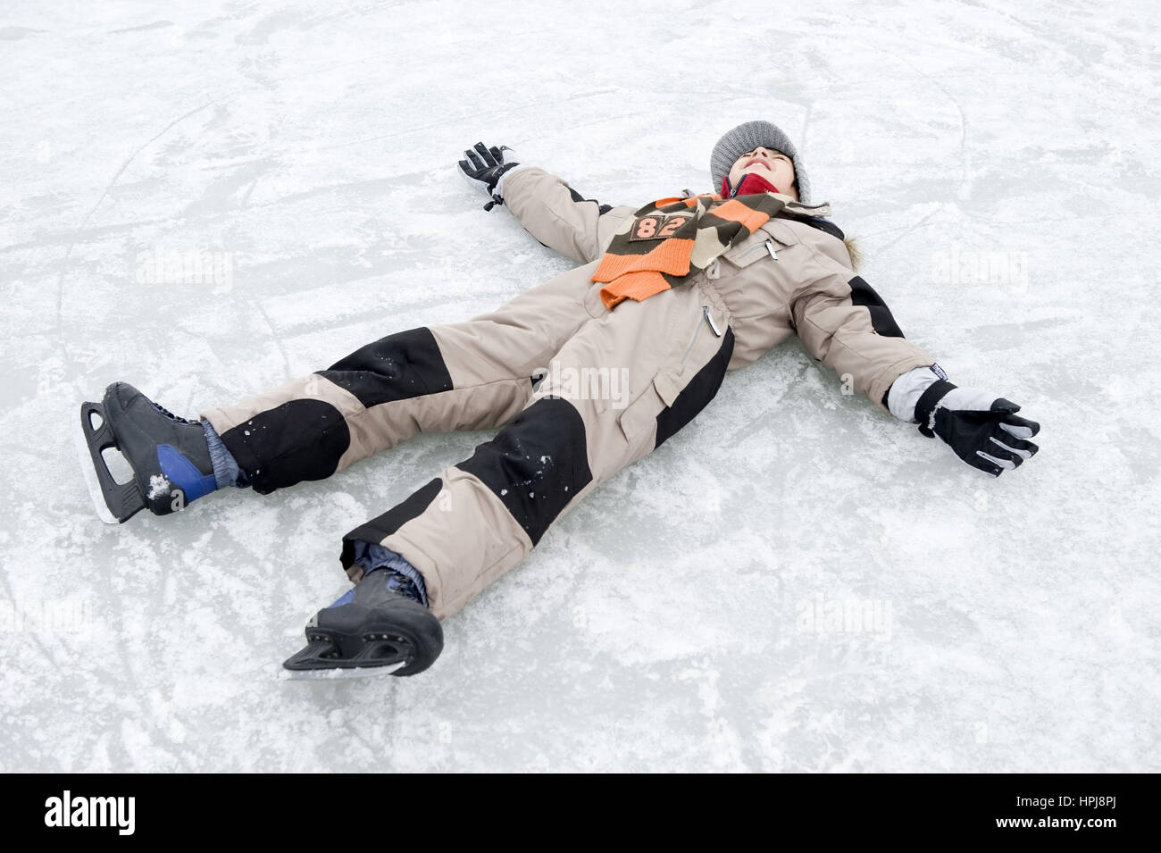 Modell veröffentlicht, Junge Mit Eislaufschuhen so bin Eis - liegen junge auf Eisbahn Stockfoto