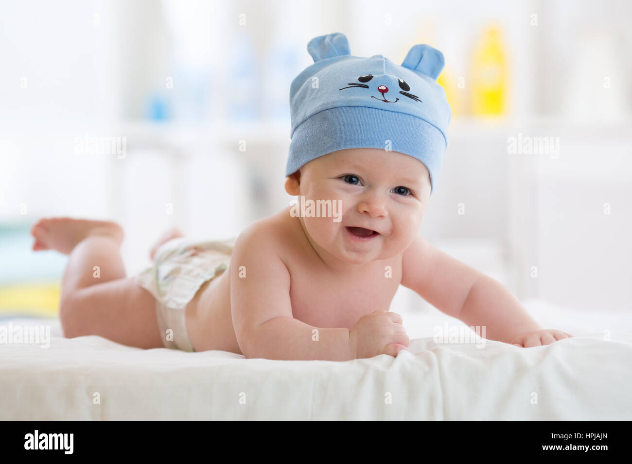 lustige Baby junge liegend auf Bauch im Bett im Wohnzimmer Stockfoto