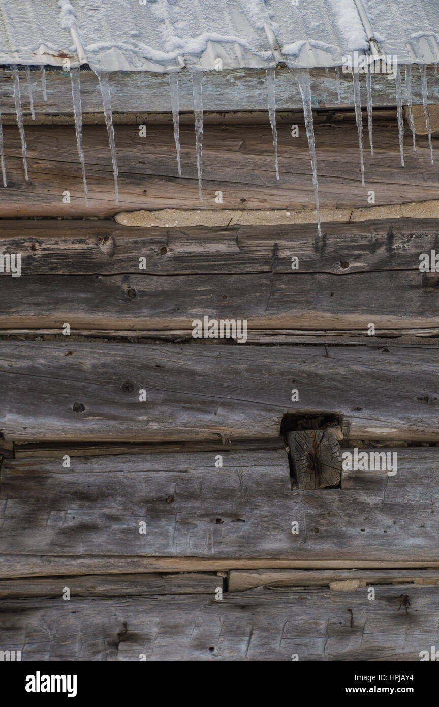 Winter schneebedeckten Scheune Pionier Blockhaus mit Eiszapfen. Sonniger Tag.  Closeup Stockfoto