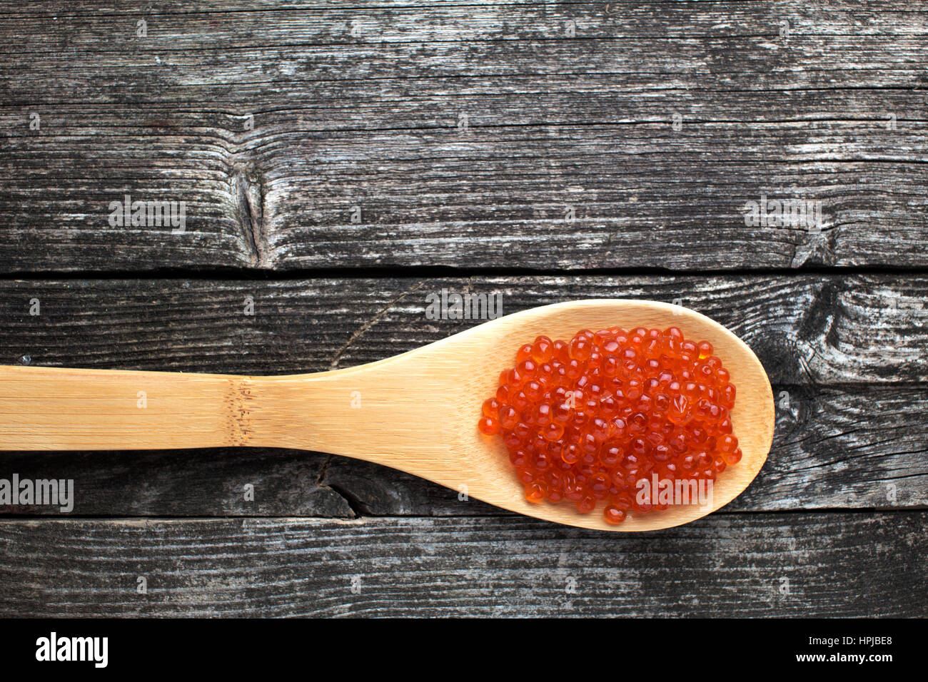 Roter Kaviar Luxus Delikatesse auf Holzlöffel auf rustikalen Hintergrund. Russische Küche Stockfoto