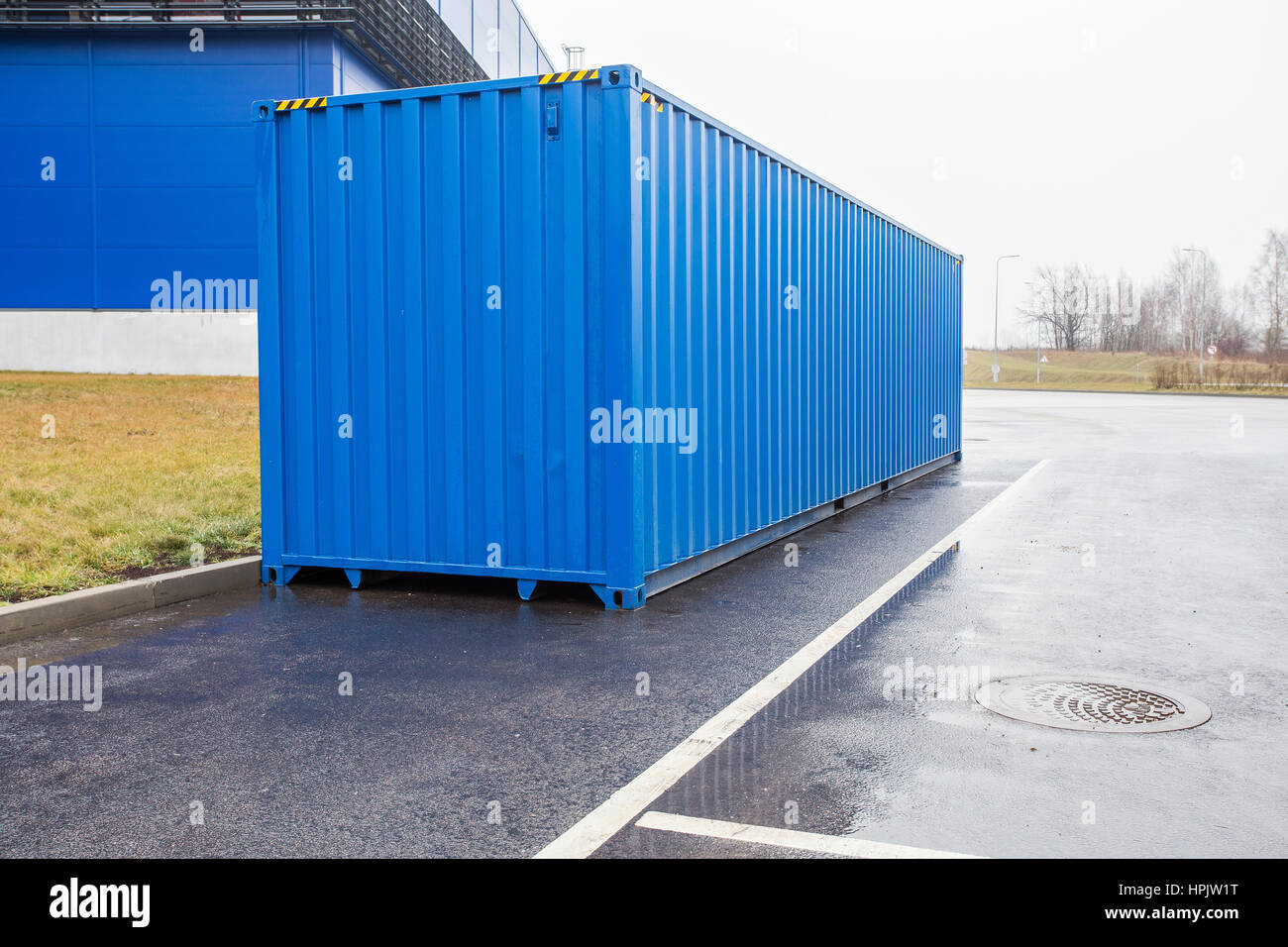 Blaue Transportbehälter auf Parkplatz Stockfoto