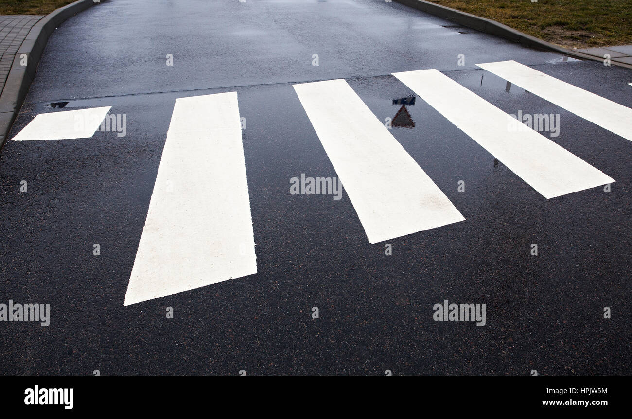 Fußgängerzone Zebrastreifen auf nassem Asphalt Straßenansicht Stockfoto