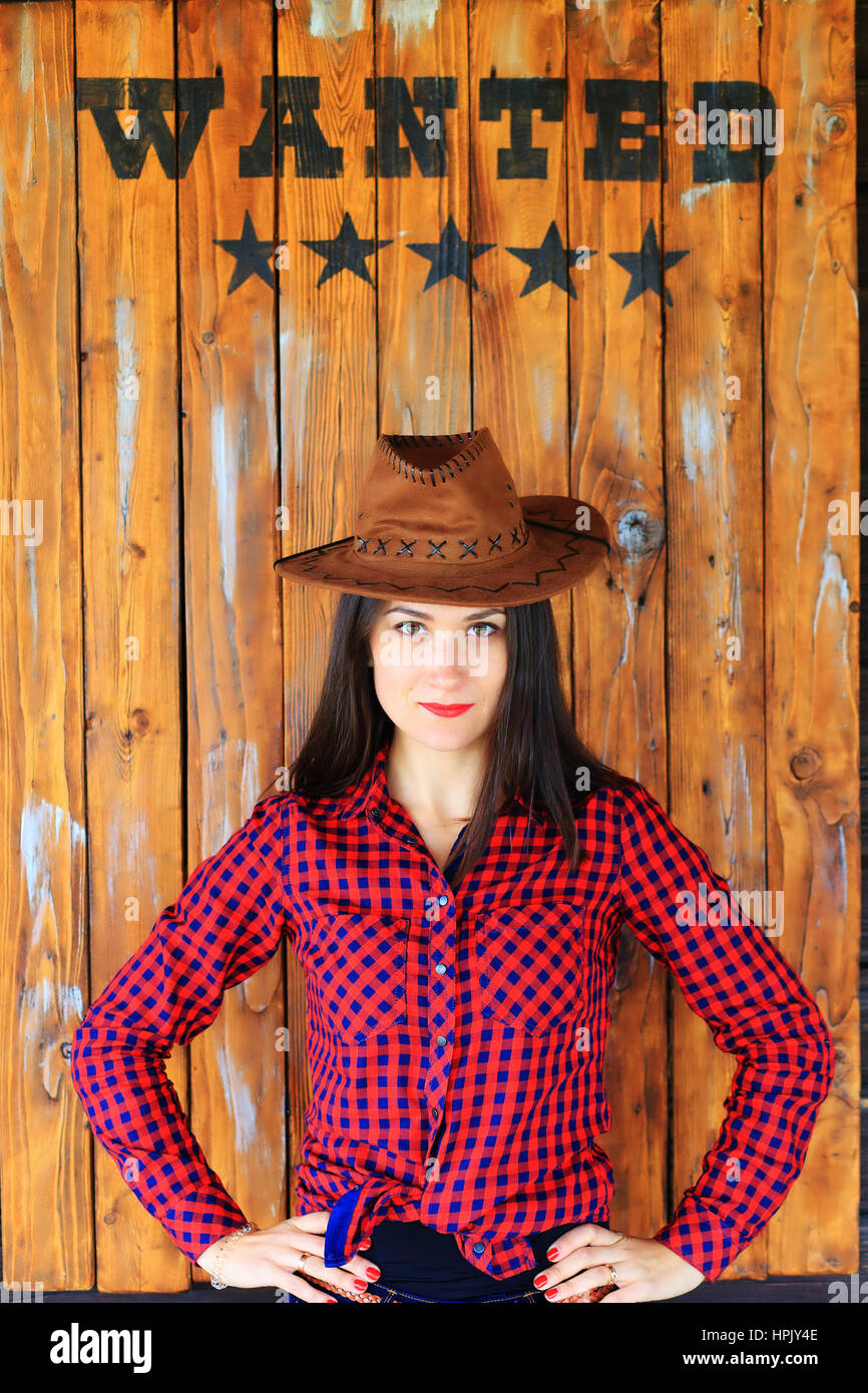 Wollte Wort über Mädchen in Cowboy-Stil auf hölzernen Hintergrund Stockfoto