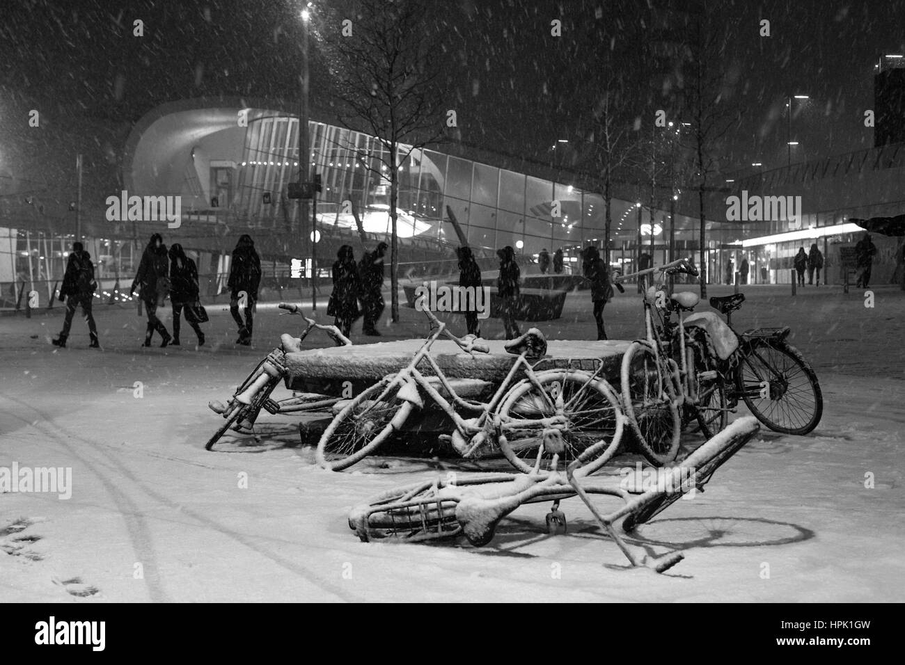 Unbeaufsichtigte Fahrräder bedeckt im Schnee am Hauptbahnhof in Arnhem, Niederlande. Stockfoto