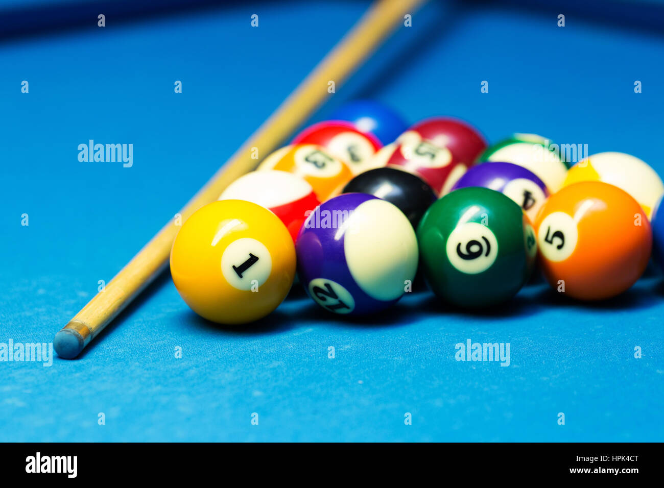 Pool-Billard-Kugeln und Cue auf dem blauen Tuch Tisch Stockfoto