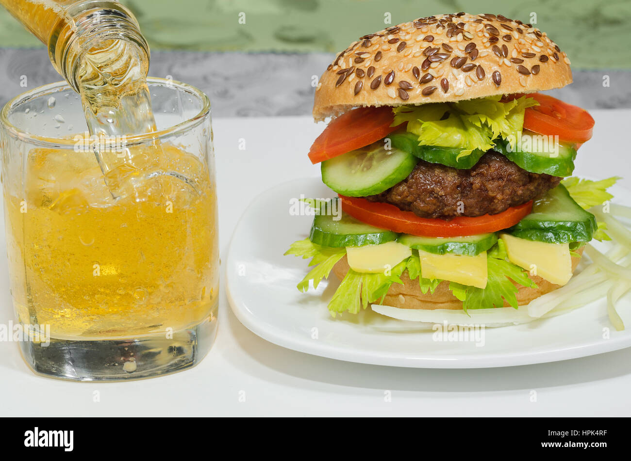 Tolle Burger und Bier wird in einem Glas Nahaufnahme gegossen. Stockfoto