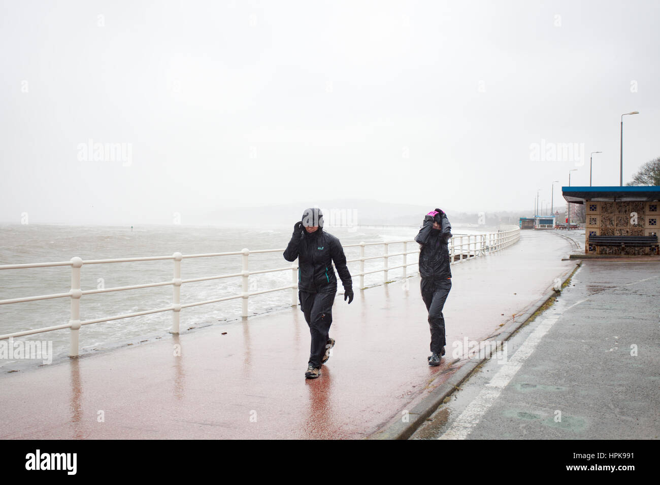 Mann und Frau trotzen Sturm Doris auf der Promenade in Colwyn Bay, North Wales, UK Stockfoto