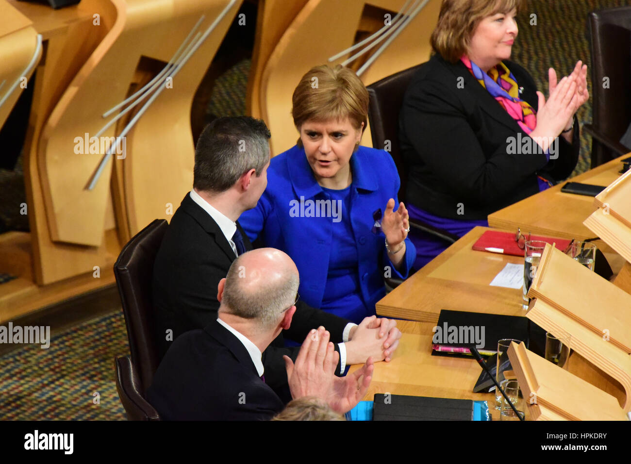 Edinburgh, Schottland, Vereinigtes Königreich. 23. Februar 2017. First Minister Nicola Sturgeon (C) gratuliert Finanz-Sekretär Derek Mackay (L) als Stufe 3 und abschließenden Debatte über den schottischen Haushalt erfolgt durch die Regierung, Credit: Ken Jack/Alamy Live News Stockfoto