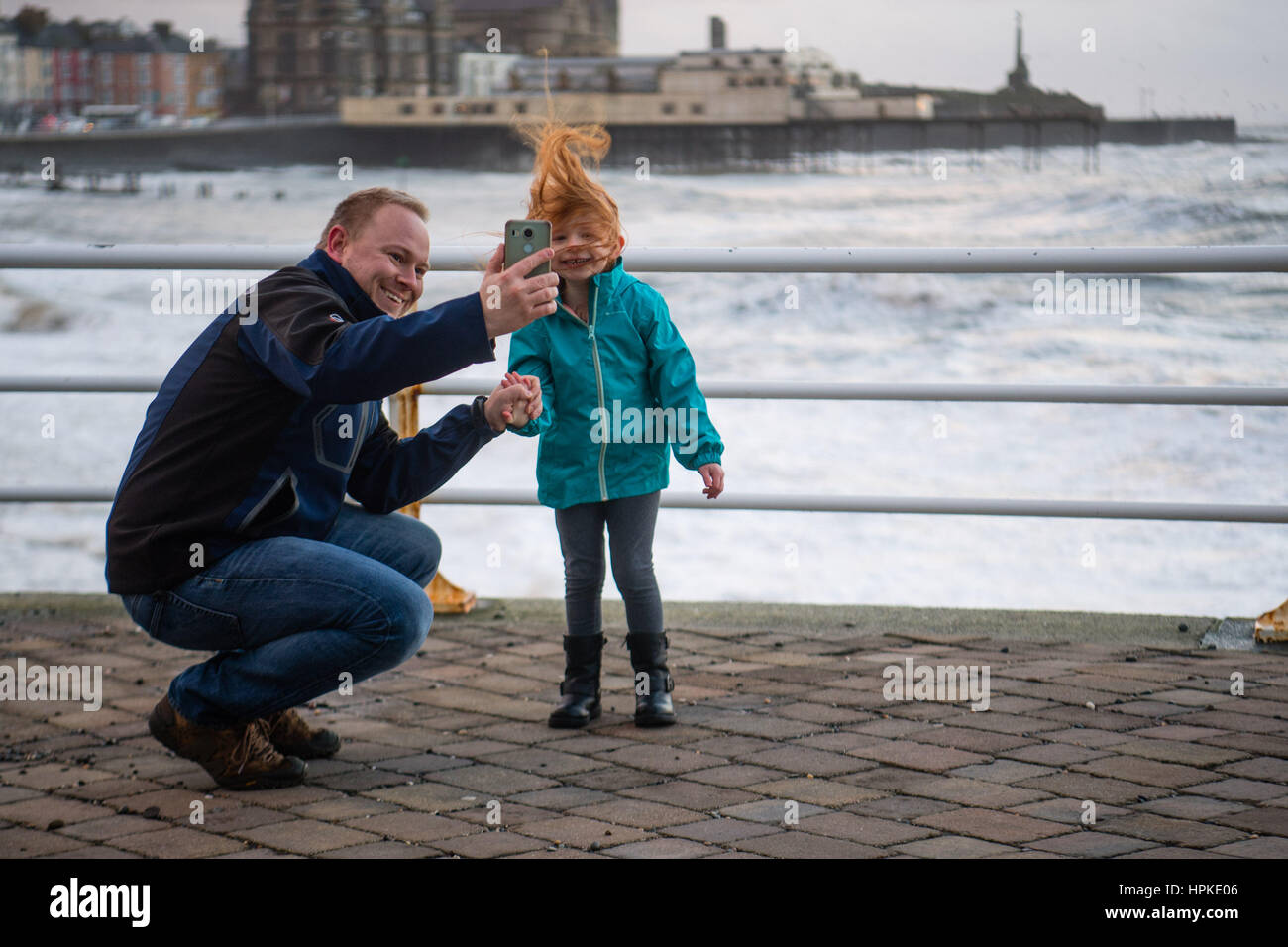 Aberystwyth, Wales, UK. 23. Februar 2017. UK-Wetter: Ein Vater nimmt ein Selbstporträt mit seiner jungen Daighter bei Sonnenuntergang in Aberystwyth nach der Ansturm der Sturm Doris Sturm Doris war die vierte benannt Sturm des Winters, und wurde als eine "Wetter-Bombe" eingestuft (explosive Zyklogenese) von der Met Office Photo Credit: Keith Morris/Alamy Live News Stockfoto