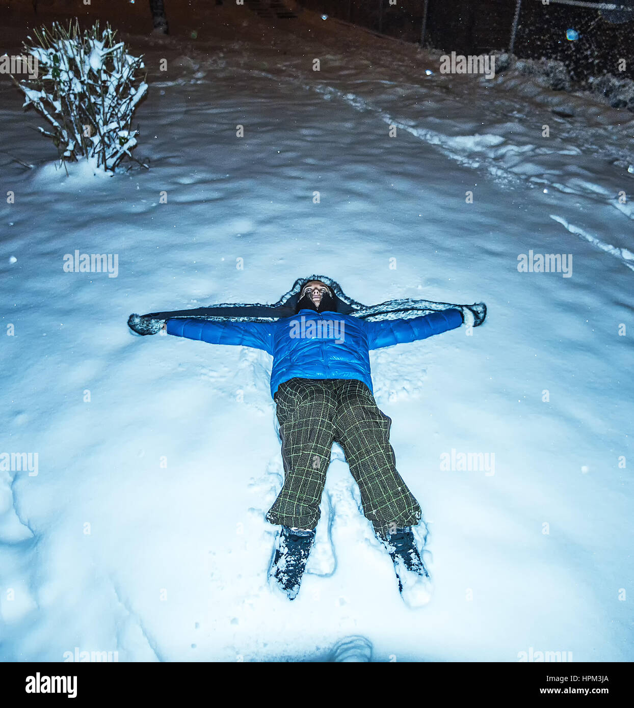 blaue Mädchen Jacke Furhat liegenden Schnee in der Nacht Stockfoto