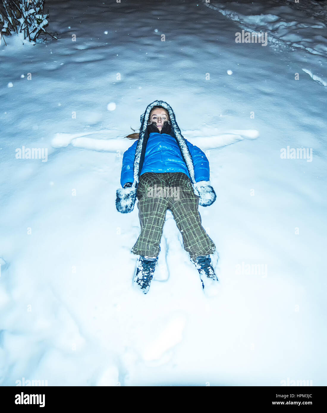 blaue Mädchen Jacke Furhat liegenden Schnee in der Nacht Stockfoto