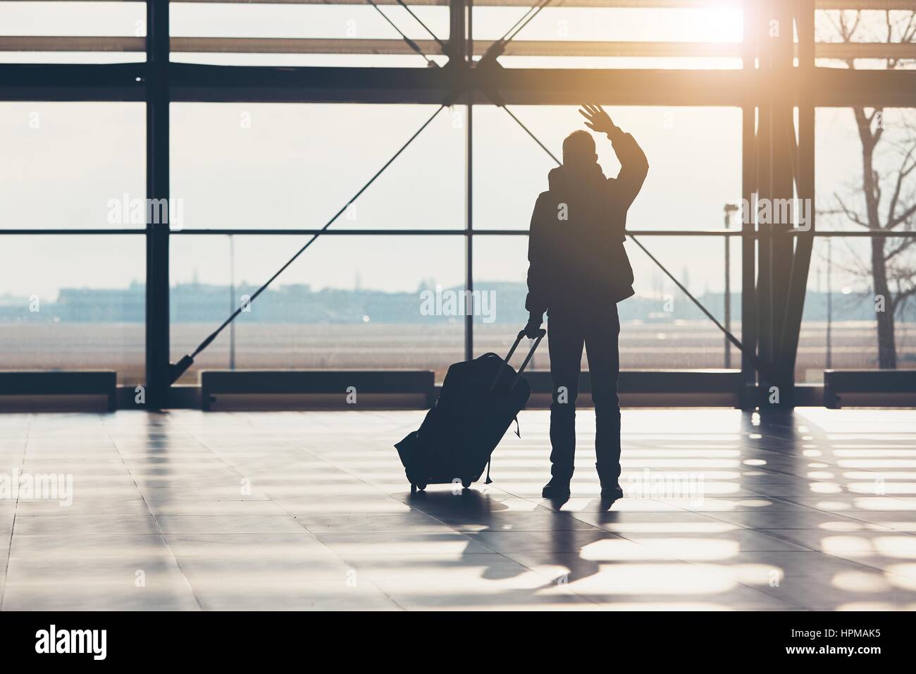 Abschied am Flughafen. Silhouette des Reisenden "Wellenlinien" seine Hand. Stockfoto