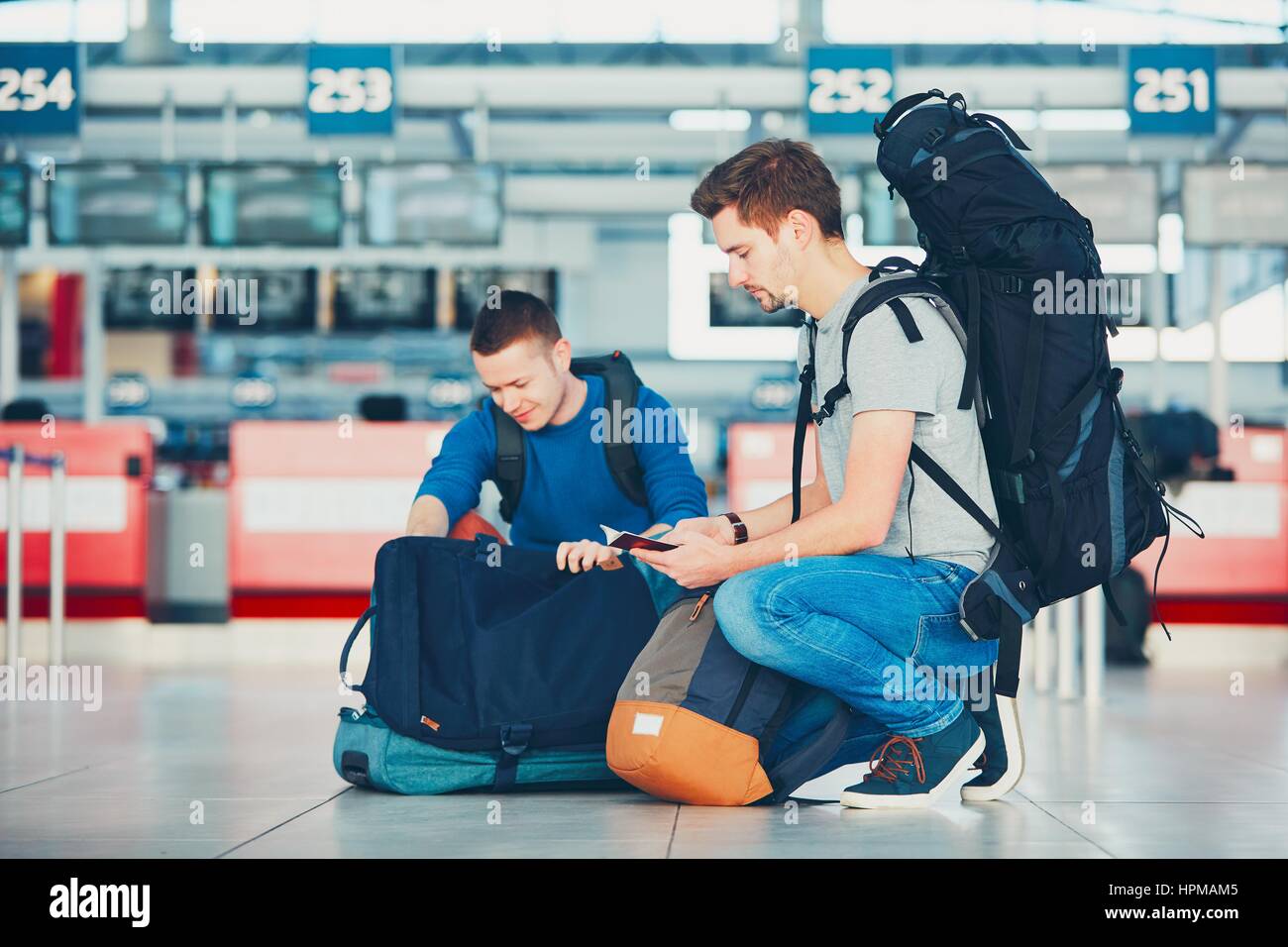 Zwei Freunde, Reisen mit dem Flugzeug. Reisende, die Vorbereitung einen Reisepass und ein Flugticket am Flughafen einchecken. Stockfoto