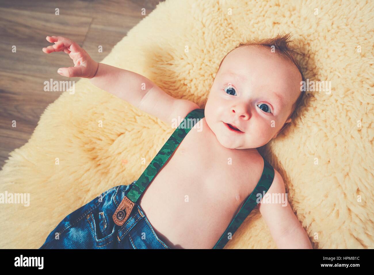 Kleinen Jungen zu Hause. Entzückende Baby ruht auf den Pelz Decke. Stockfoto