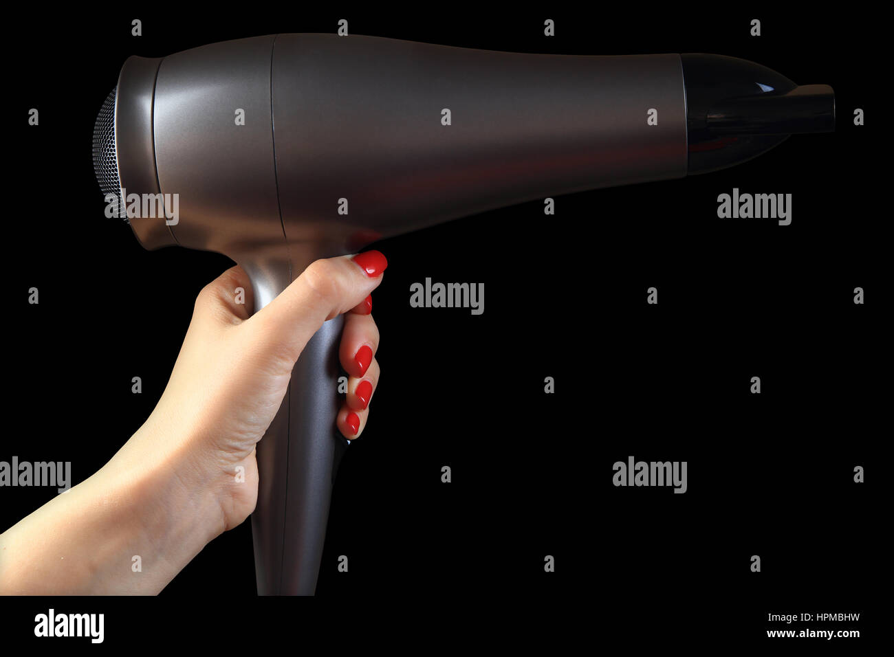 Haartrockner in weiblicher Hand. Hintergrund zurück. Hand mit roten Nägeln. Stockfoto