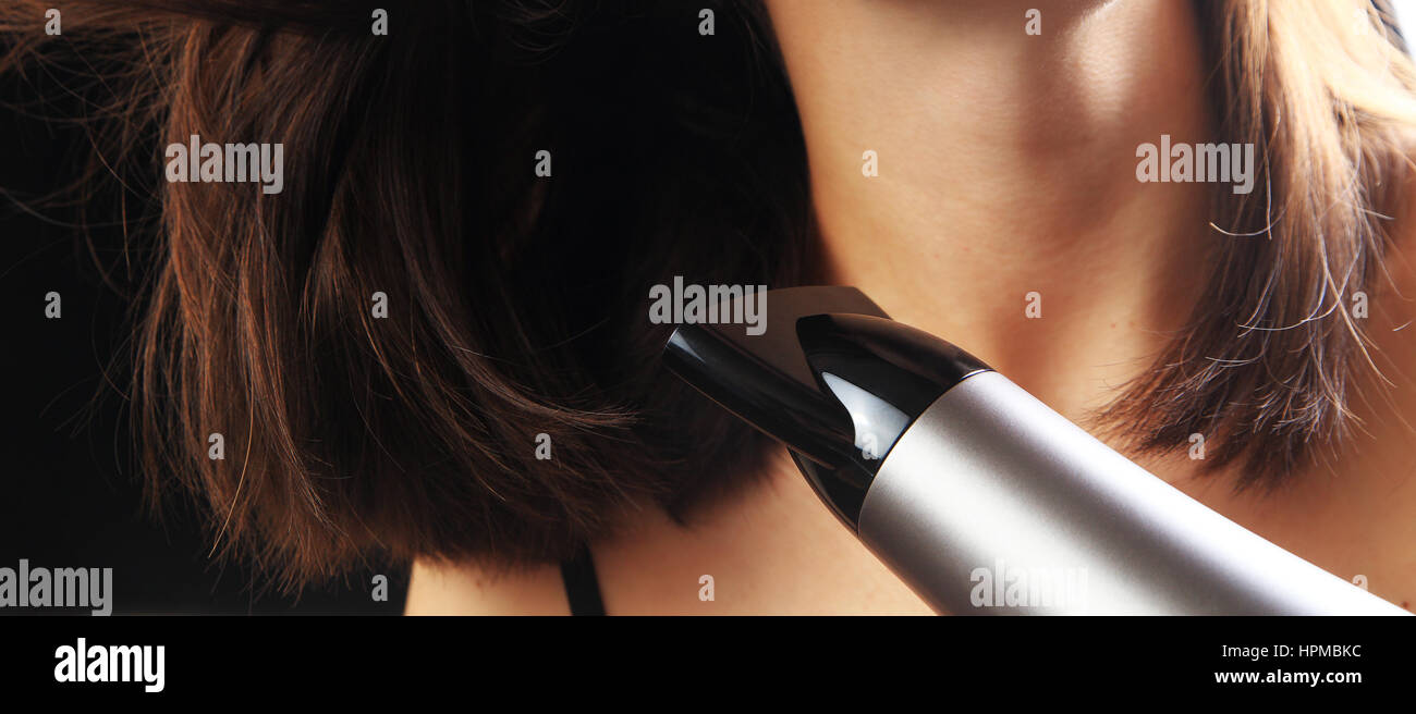 Trockenes Haar Mädchen mit Fön auf schwarzem Hintergrund isoliert Stockfoto
